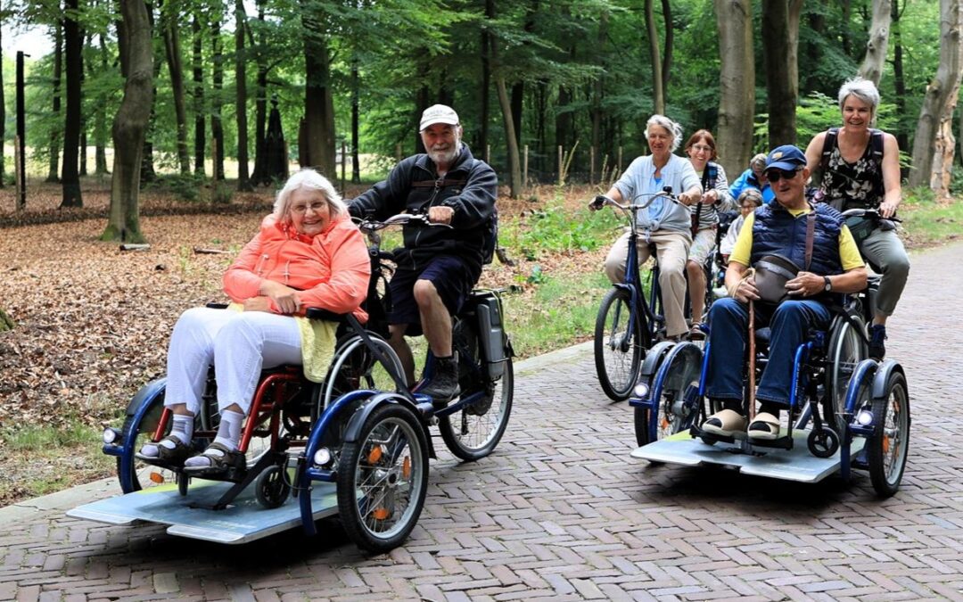 Ferien in Holland - zwei Personen im Handrollstuhl unterwegs auf einem Cargo-Fahrrad